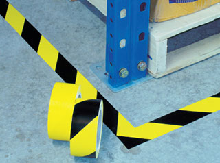 Safety marking tape black yellow stripes on floor at warehouse